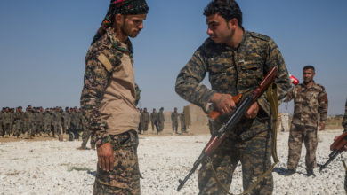An instructor with the Syrian Democratic Forces observes a Syrian Arab trainee clear his rifle during small arms training in Northern Syria,