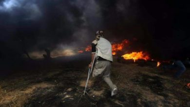 A Palestinian man in Gaza approaches a tire fire