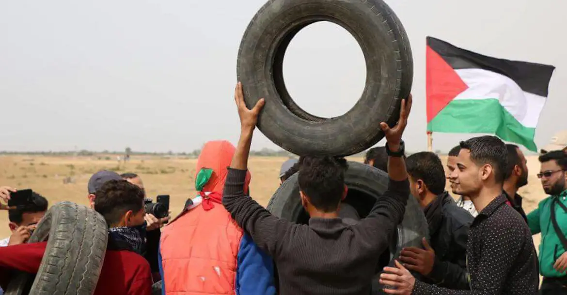 A group of young men in Gaza prepare to light tires on fire ahead of a protest