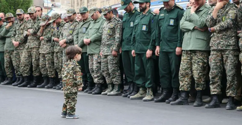 Islamic Revolutionary Guard Corps officers in tears as they look at the son of one of their colleagues, Akbar Zavar Jannati, who was killed in an airstrike in Syria