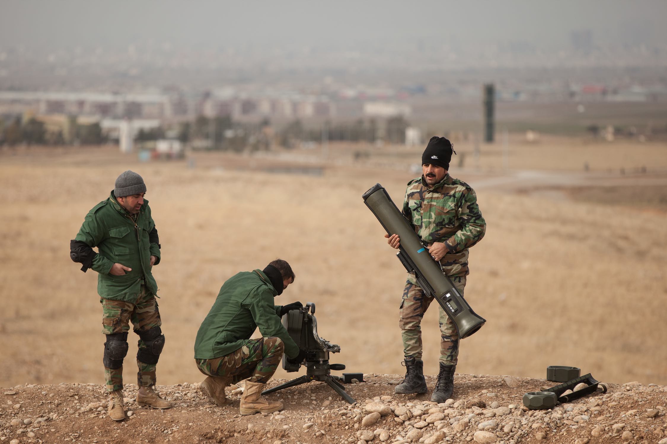 Peshmerga soldiers disassemble a Milan anti- tank missile system