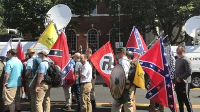Alt-right members preparing to enter Emancipation Park holding Nazi, Confederate Battle, Gadsden "Don't Tread on Me," Southern Nationalist, and Thor's Hammer flags.