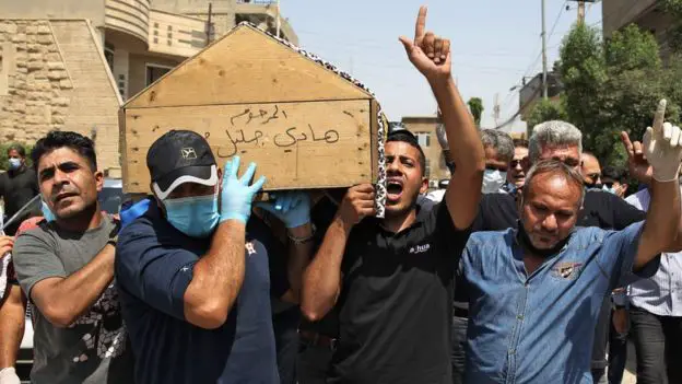 Mourners carry Hisham al-Hashemi's coffin.