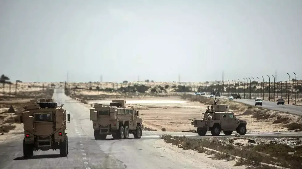Egyptian officers drive on a route leading to El-Arish, the capital of North Sinai province, Egypt, on July 26, 2018.