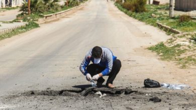 A Syrian man collects samples from the site of a suspected toxic gas attack in Syria's Idlib province, April 5, 2017