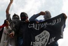 Islamic State supporters hold up the caliphate's flag