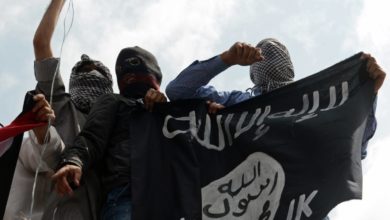 Islamic State supporters hold up the caliphate's flag