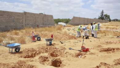Libyan Ministry of Justice employees dig at the site of a suspected mass grave in Tarhouna, Libya on June 23, 2020.