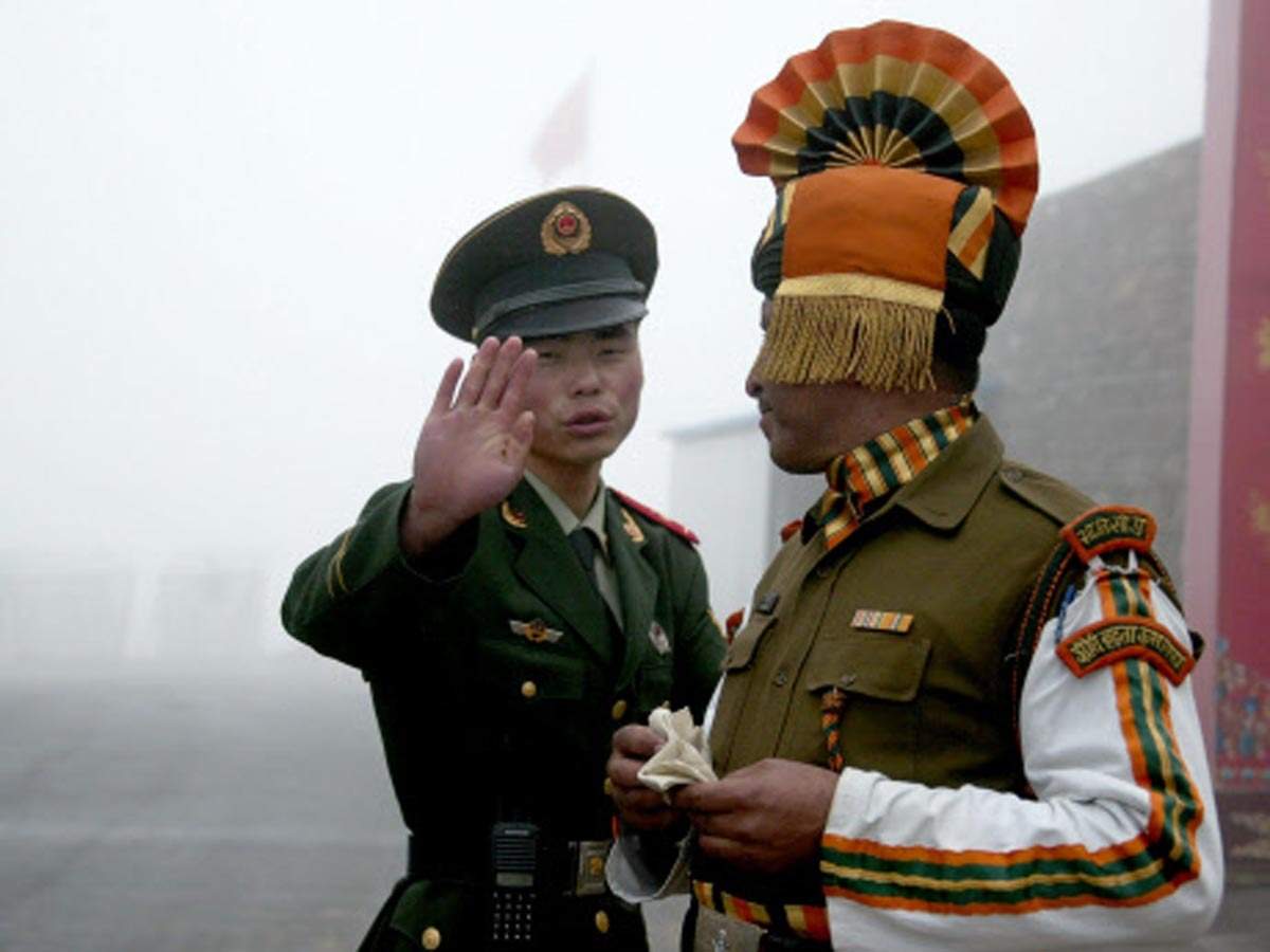 A Chinese and an Indian soldier at their countries' border along the Himalayas.