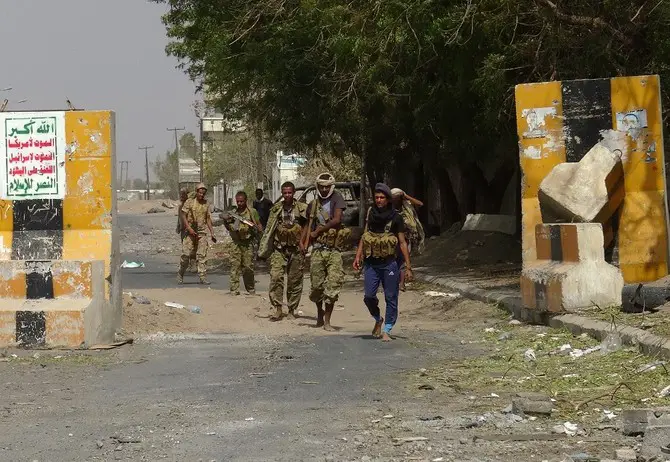 Armed Yemeni soldiers walk on.