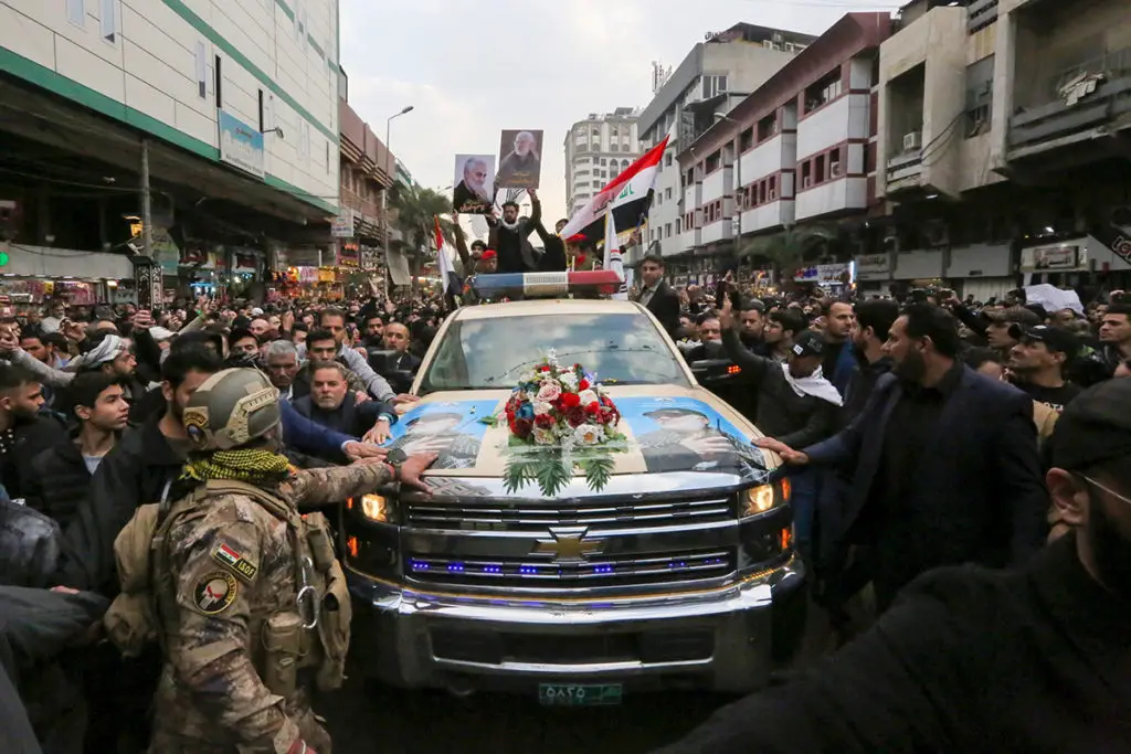 Mourners surround a car carrying the coffins of Iranian military commander Qasem Soleimani and Iraqi paramilitary chief Abu Mahdi al-Muhandis, killed in a US air strike, in Baghdad on January 4, 2020. Photo: Sabah Arar/AFP.