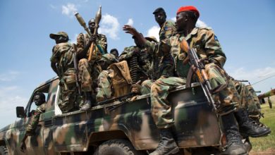 South Sudanese government soldiers sit in a pick-up truck at the military base in Malakal, northern South Sudan, on October 16, 2016.