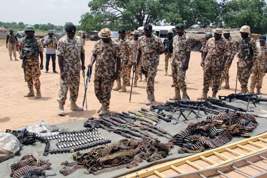 Military troops inspect arms and ammunitions recovered from Boko Haram jihadists.