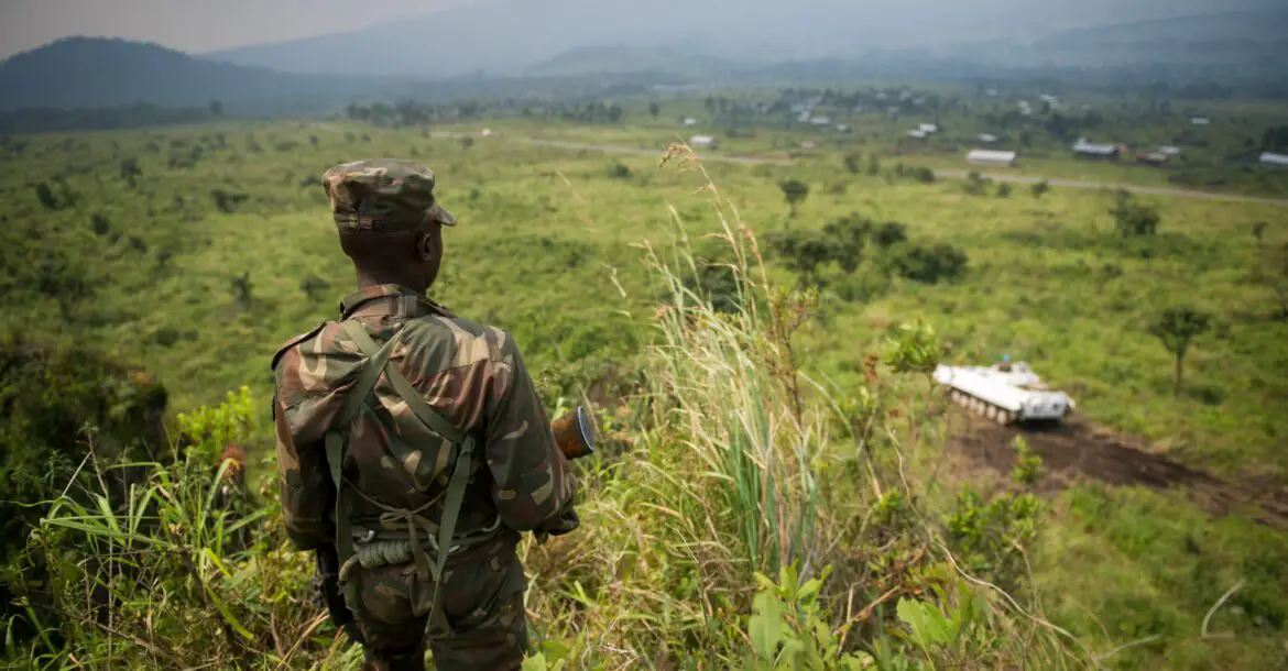 A soldier from the Armed Forces of the Democratic Republic of the Congo (FARDC) stands guard on a hill overlooking a United Nations tank position near the village of Kibumba I, around 20km from the city of Goma in the Democratic Republic of the Congo's restive North Kivu province on July 11, 2012.