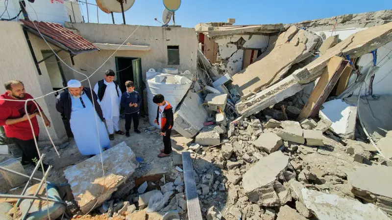 Civilians examining a damaged building.