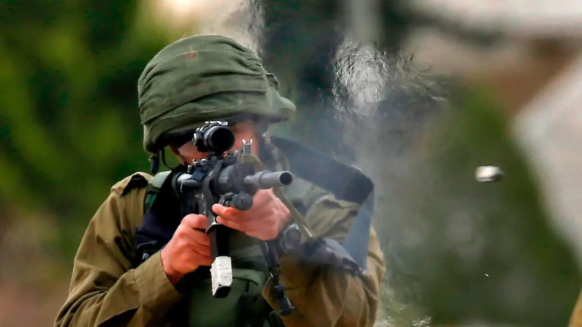 An Israeli soldier fires rubber bullets at Palestinian protesters during a weekly demonstration against the expropriation of Palestinian lands in the occupied West Bank, on February 1, 2019