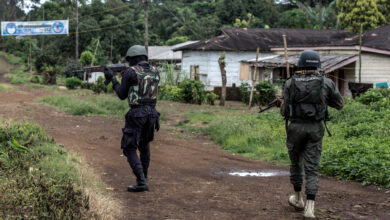 A Cameroonian policeman and a gendarme securing the perimeter of a polling station in Lysoka, near Buea, southwestern Cameroon, on October 7, 2018.