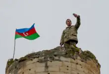 An Azerbaijani soldier takes a selfie with the national flag in Fuzuli, a liberated city, last November 26, 2020.