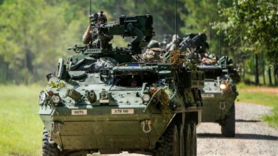 A column of eight-wheeled Stryker combat vehicles moves along a road at Fort Benning, Georgia, September 2, 2020 during training