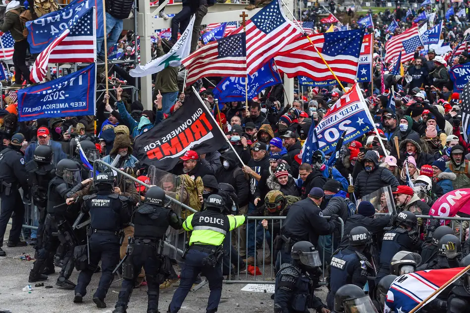 Police and security forces attempt to hold back a mob of pro-Trump extremists as they storm the US Capitol in Washington on January 6, 2021.