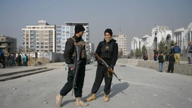 Policemen stand guard at the site of a bomb blast in Kabul on February 2, 2021.