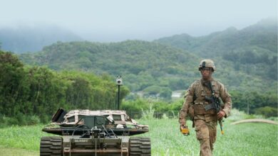 A US Army Pacific soldier walks down a trail 22 July 2016 while controlling an unmanned vehicle as part of the Pacific Manned Unmanned–Initiative at Marine Corps Training Area Bellows, Hawaii.