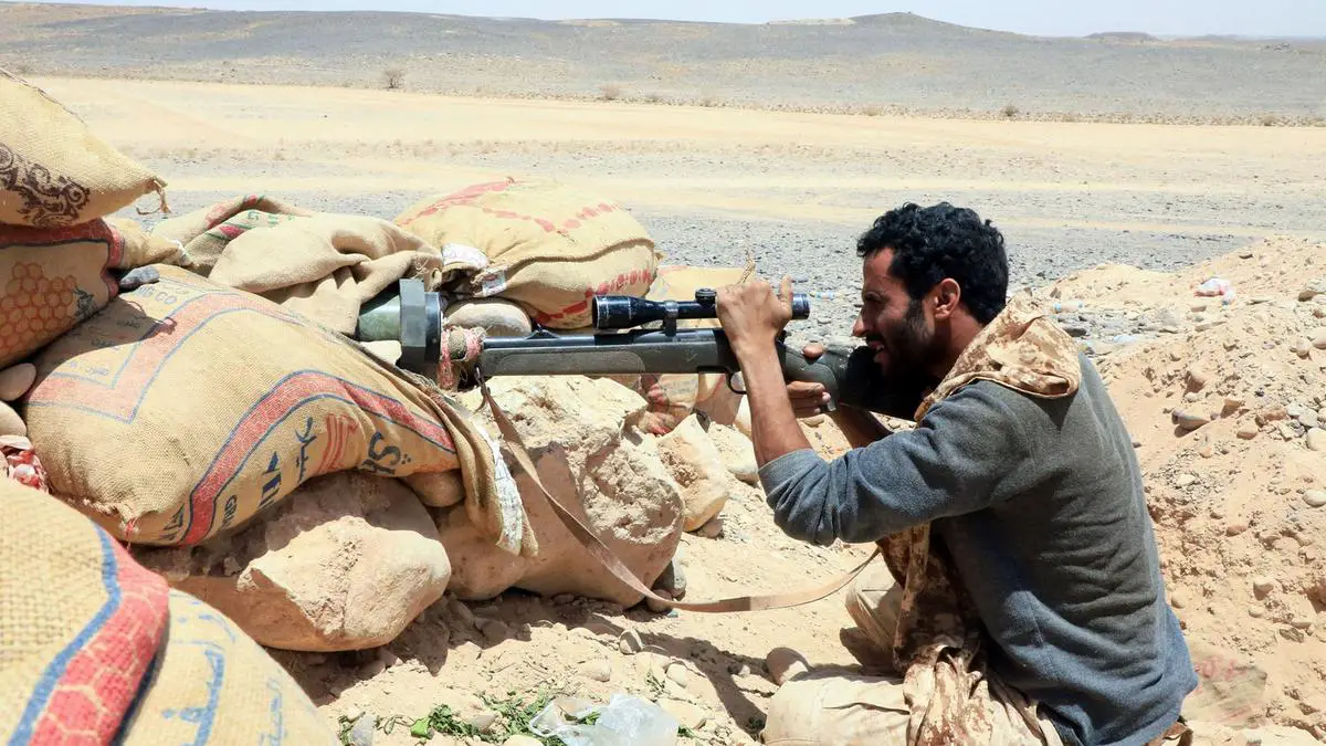 A fighter loyal to Yemen’s government holds a position against Houthi rebels in Marib