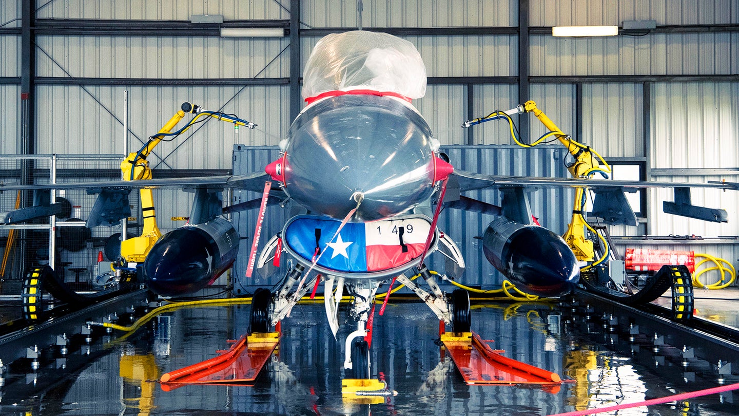 An F-16 fighter jet being washed by an automated cleaning system at Joint Base San Antonio-Lackland, Texas