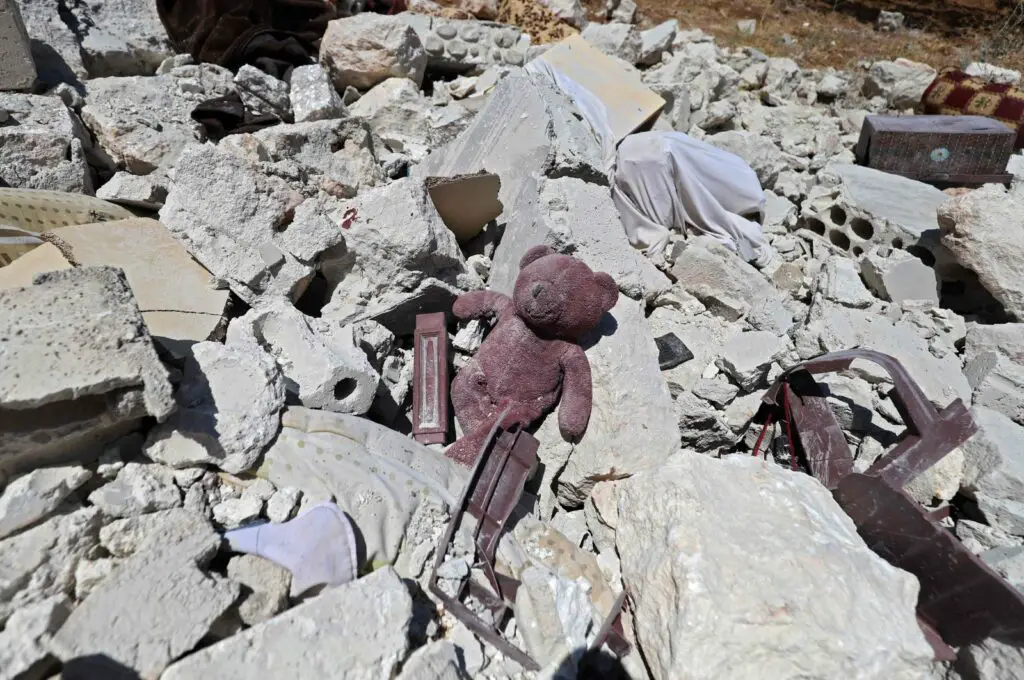 A child's teddy bear is pictured amidst the rubble of a house, following reported shelling by regime forces, in the village of Serja, in the southern part of Syria's Idlib province