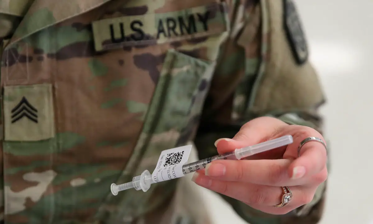 A US army personnel holds a vaccine