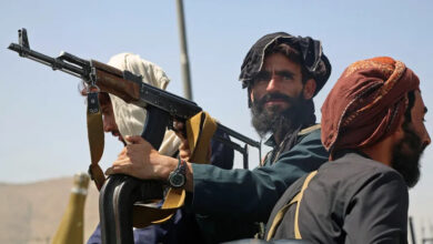 Taliban fighters stand guard in a vehicle along the roadside in Kabul on August 16, 2021