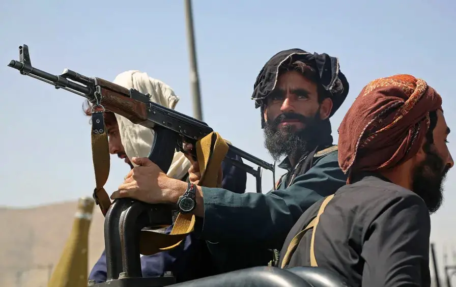 Taliban fighters stand guard in a vehicle along the roadside in Kabul on August 16, 2021