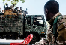 Members of the Amhara Special Forces seat on the top of a truck while another member looks on in the city of Alamata, Ethiopia, on December 11, 2020