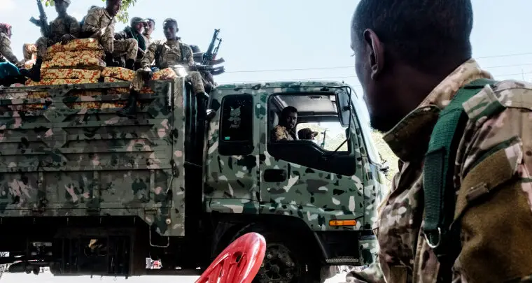 Members of the Amhara Special Forces seat on the top of a truck while another member looks on in the city of Alamata, Ethiopia, on December 11, 2020