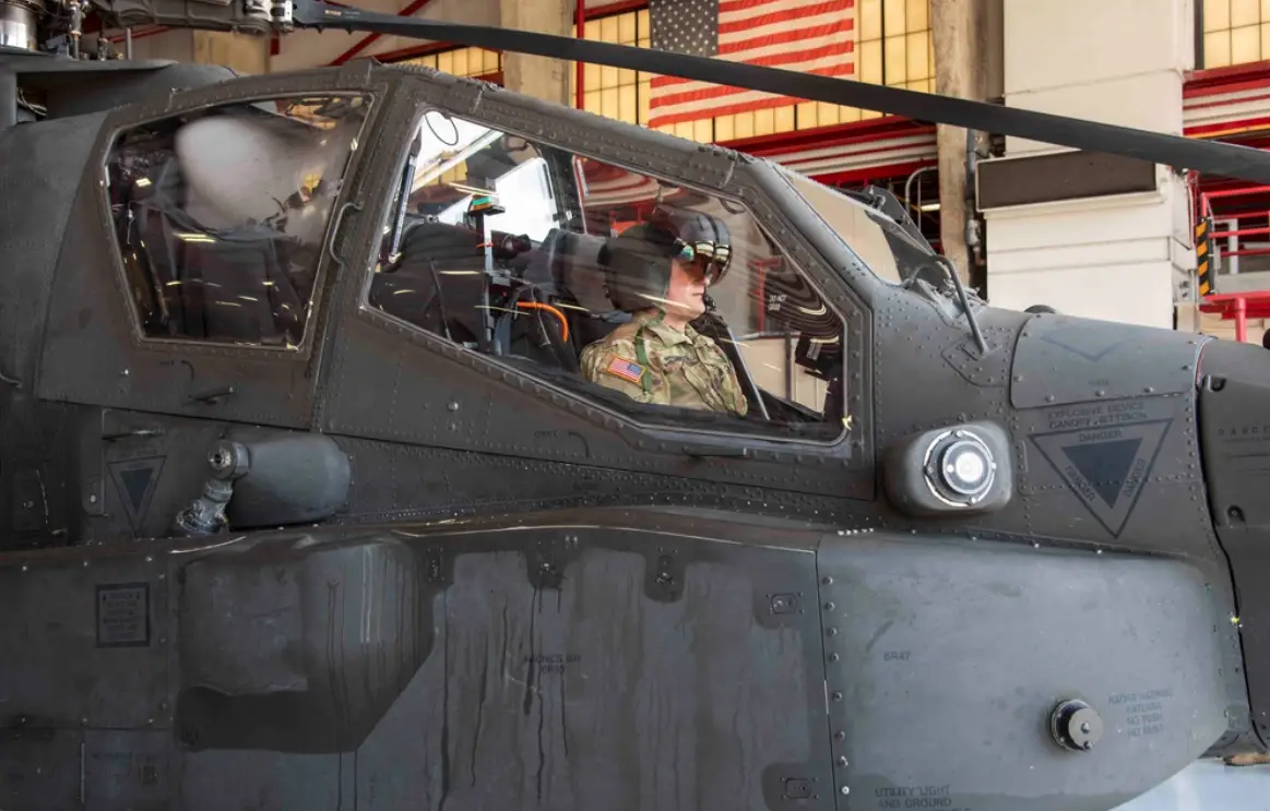 A US Army pilot observes the features of an enhanced Helmet Mounted Display from the front seat of an AH-64E Apache Helicopter