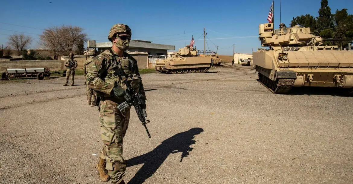 A US soldier walks near a Bradley Fighting Vehicle