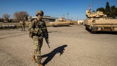 A US soldier walks near a Bradley Fighting Vehicle