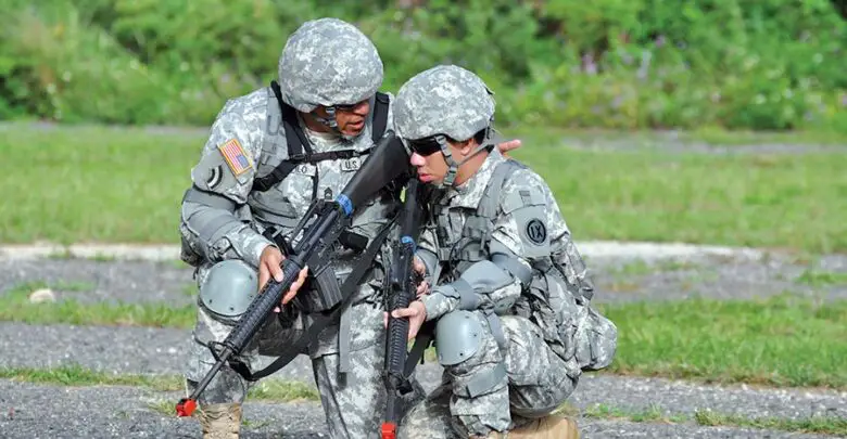 A US Army Master Sergeant provides guidance to a Pvt. during a field training exercise.