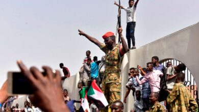 After Sudanese President Omar al-Bashir was ousted, members of the Sudanese military gather in a street with protestors in central Khartoum
