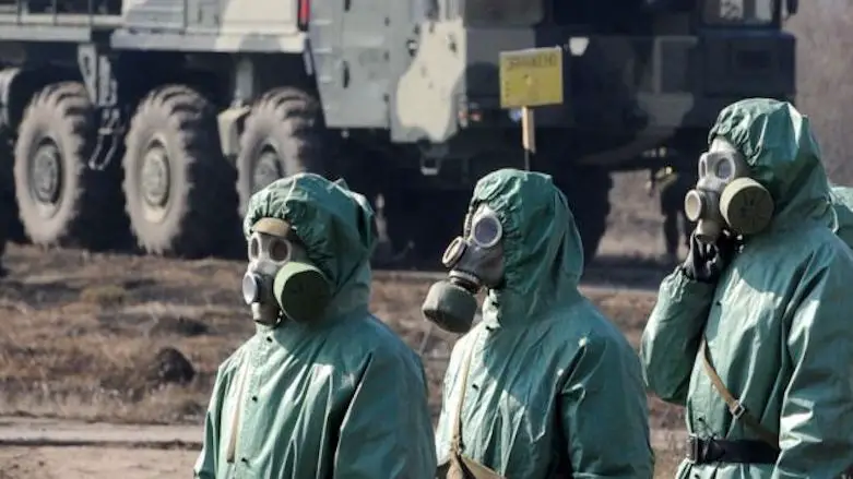 Russian soldiers wear chemical protection suits as they stand next to a military fueler on the Topol intercontinental ballistic missile base