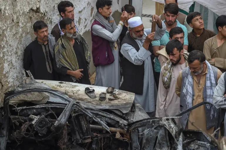 Afghan residents and family members of the victims gather at the site of deadly US drone attack in Kabul