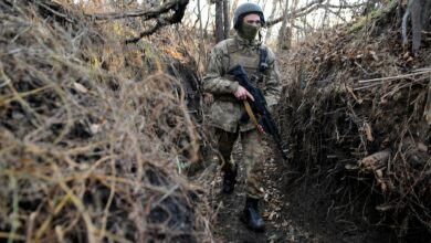 Ukrainian serviceman walks along trench