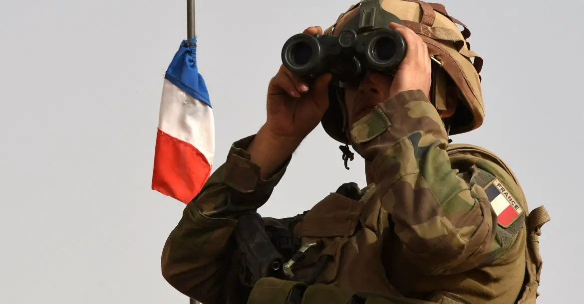 A French soldier looks through binoculars