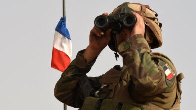 A French soldier looks through binoculars