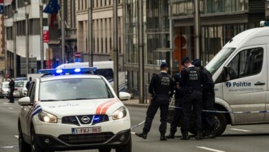 Policemen stand guard near a security perimeter set in the Rue de la Loi near the Maalbeek subway station, in Brussels