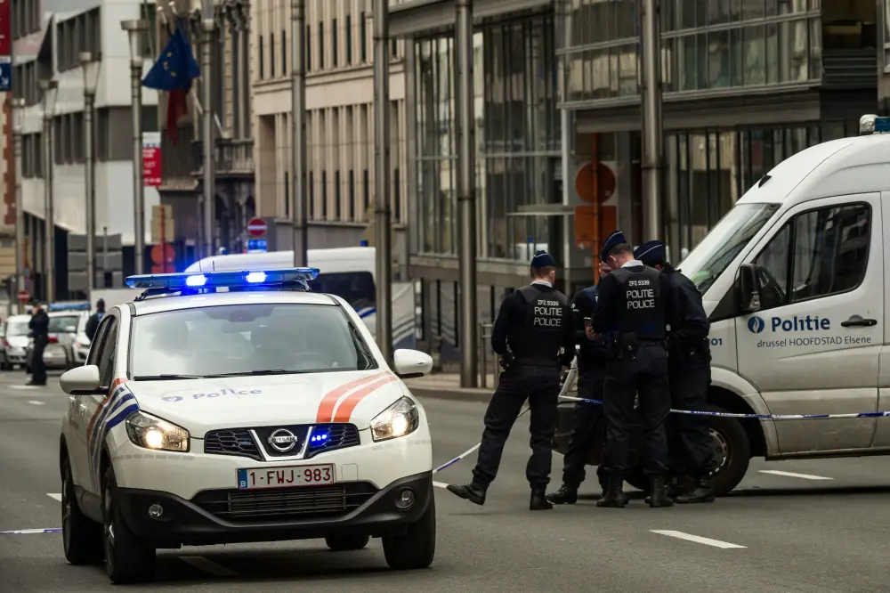 Policemen stand guard near a security perimeter set in the Rue de la Loi near the Maalbeek subway station, in Brussels