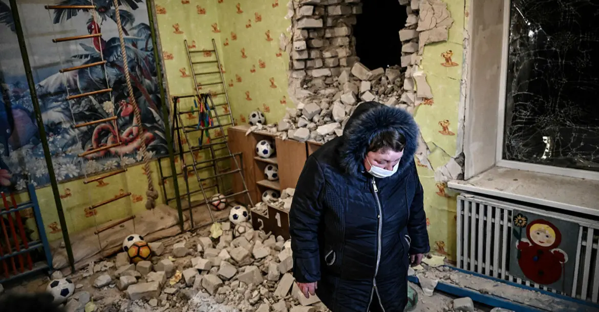A woman stands among debris after the reported shelling of a kindergarten