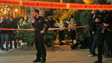 Israeli emergency personnel check the body of an alleged gunman at the scene of a shooting attack in Bnei Brak