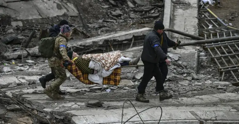 Ukrainian servicemen evacuate an elderly woman
