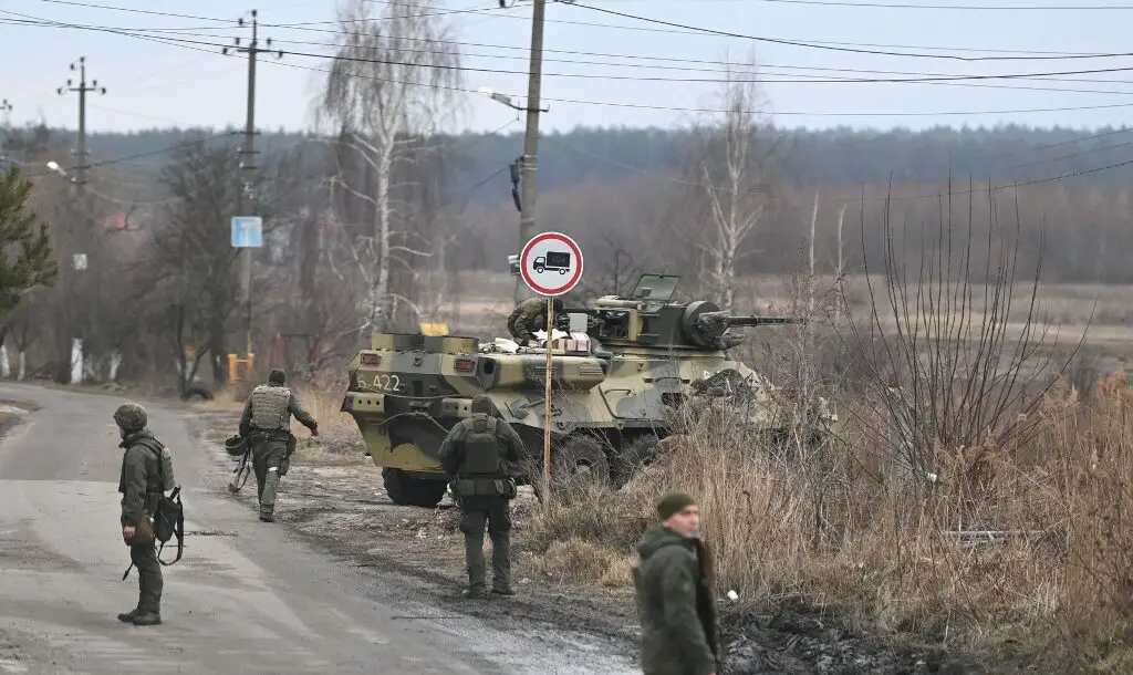 Ukrainian servicemen stand near an armored personnel carrier BTR-3
